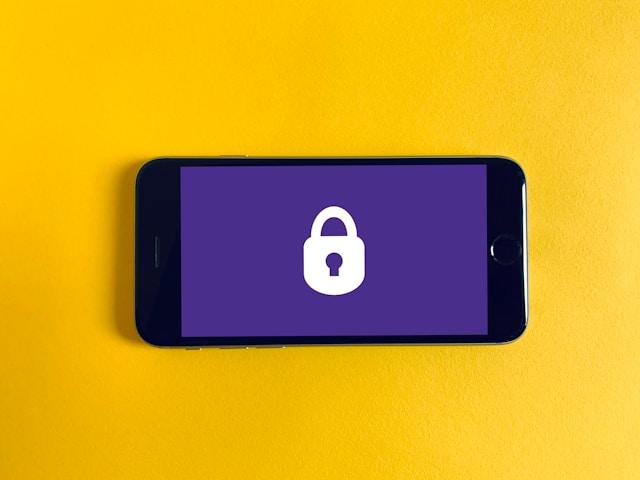 smartphone with purple lock screen on top of a yellow background